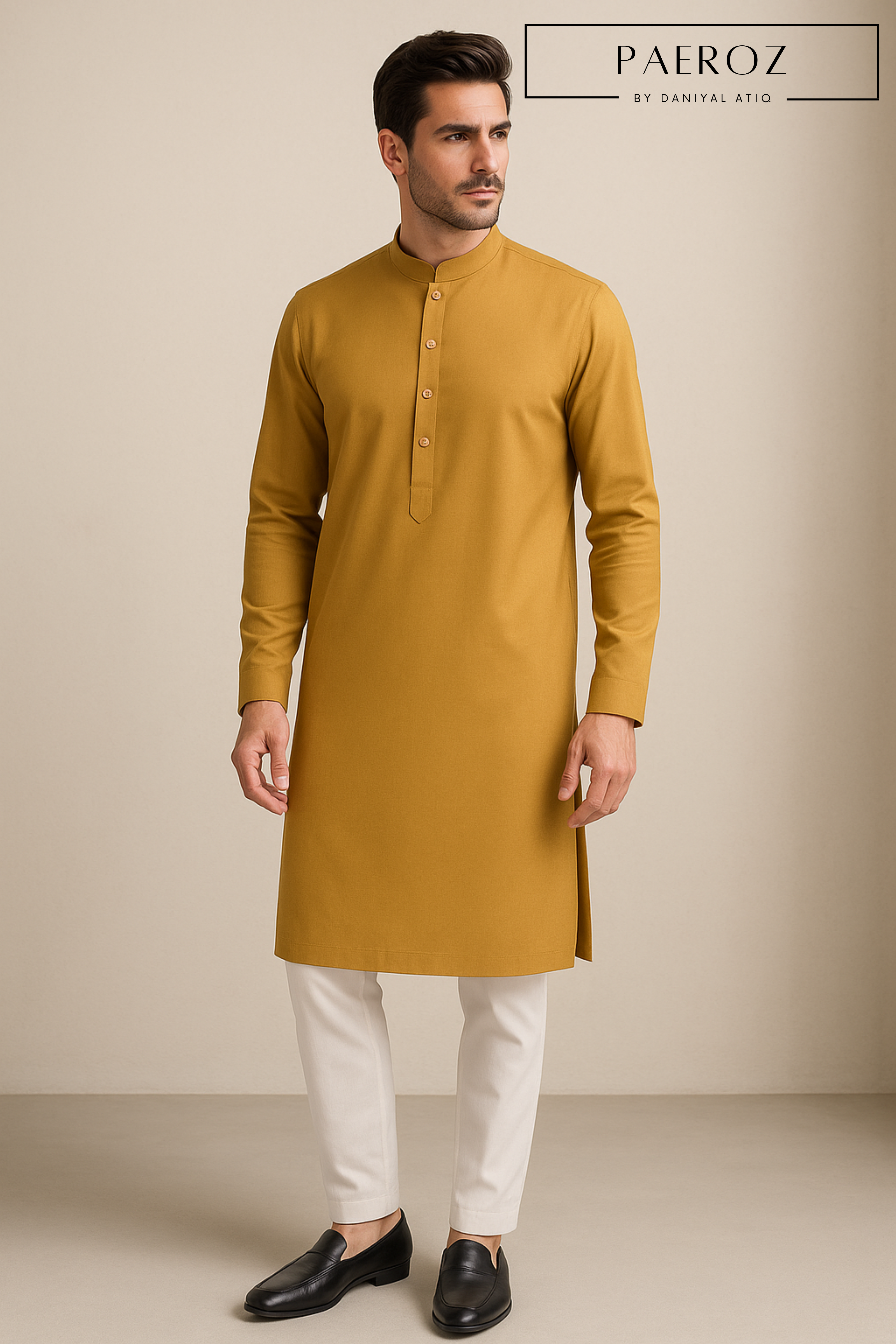 Man wearing a mustard yellow kurta with white pants on a beige background, branded 'PAEROZ'.