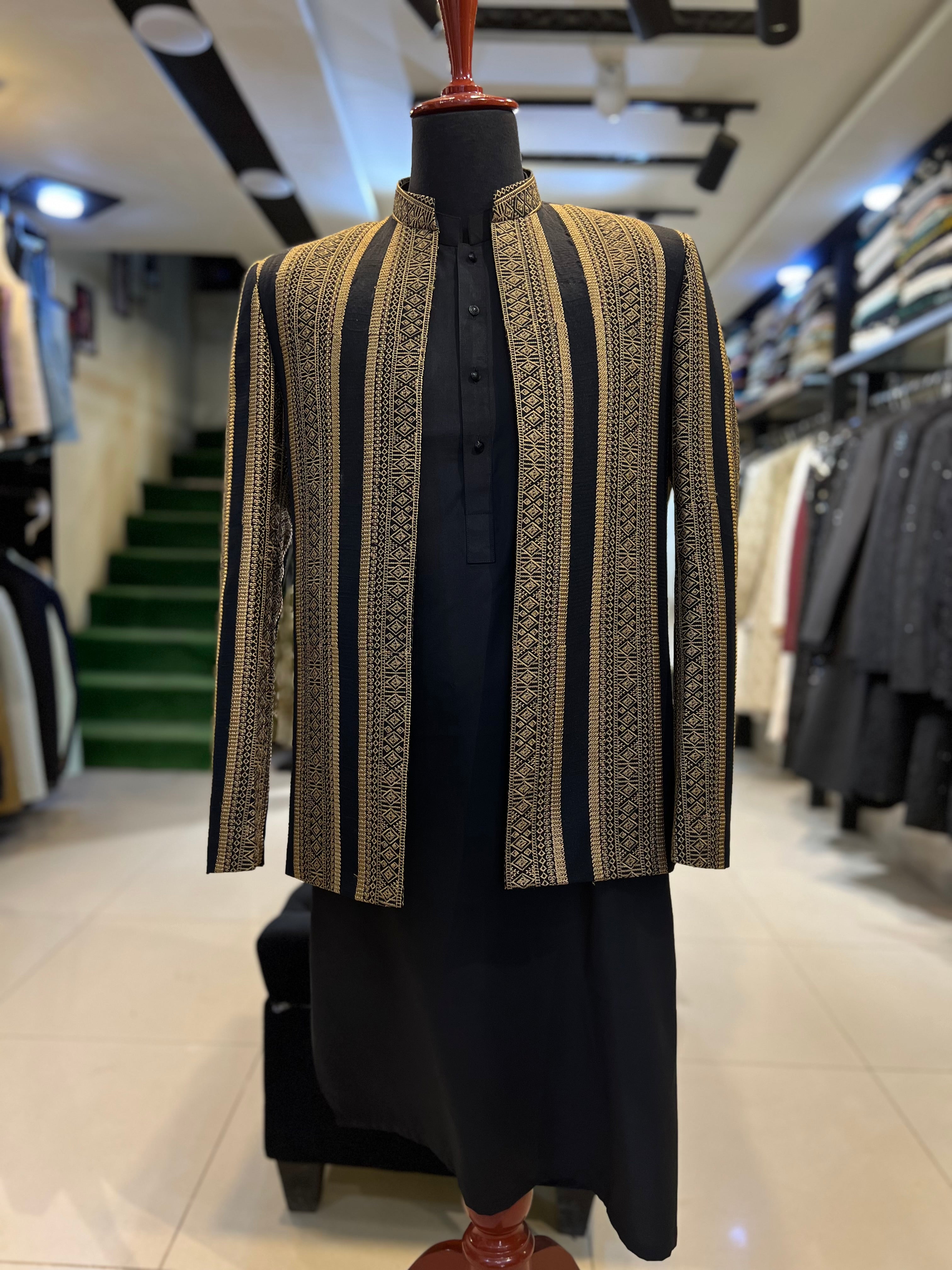 Mannequin wearing a patterned jacket and black outfit in a store setting